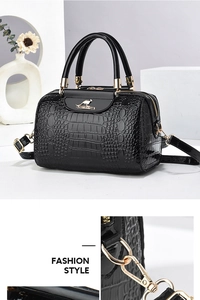 Close-up of black crocodile pattern faux leather handbag with golden kangaroo metal logo