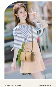 Close-up of a stylish tan leather crossbody bag with top handle on a street background