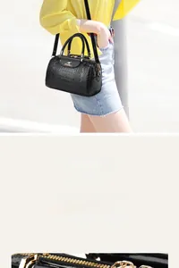 Close-up of black crocodile pattern handbag with gold hardware and kangaroo logo detail