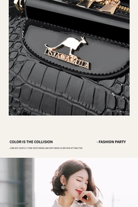 Close-up of black croc-embossed leather handbag with gold kangaroo emblem and zipper details