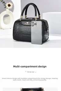 Detail of black crocodile texture handbag with gold hardware and multi-compartment interior