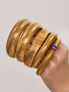 Détail de bracelets Tubogas dorés sertis d'un zircon rectangulaire violet chic