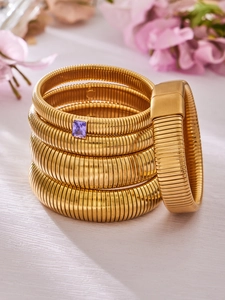 Détail de bracelets Tubogas plaqués or ornés d'une pierre précieuse de zircon violette