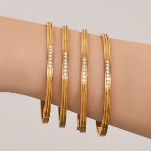 Four-piece gold stainless steel bangle set with micro-pave zircons and parallel engravings