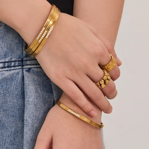316L gold geometric bangles and zircon rings set worn for a chic stacked fashion style