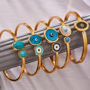 Ensemble de cinq bracelets dorés avec œil protecteur, pierres turquoise et motifs