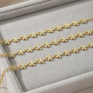 Gold-plated stainless steel chain bracelet with blue enamel daisies and lobster clasp