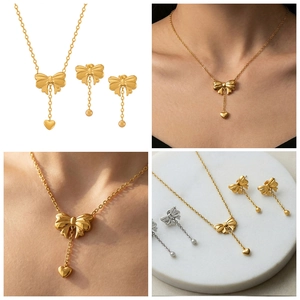Detailed close-up of gold butterfly jewelry set including necklace and earrings on marble