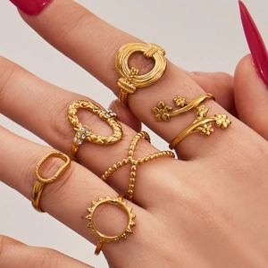 Set of 6 gold geometric heart and textured rings on model hand for modern women style