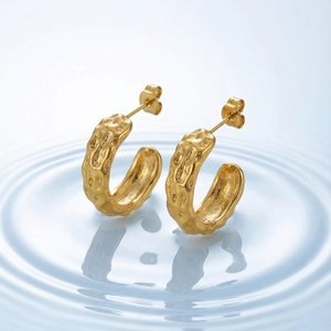 Fashionable gold C-shaped earrings with irregular lava texture and metallic finish