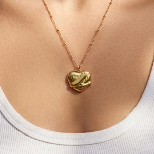Collier chaîne à billes dorée avec pendentif cœur 3D porté par un mannequin