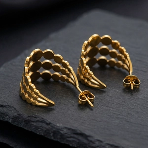 Boucles d'oreilles clous dorées en forme de C à disques superposés sur pierre noire