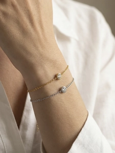 Details von eleganten Gold- und Silberkettenarmbändern mit rundem Solitärstein
