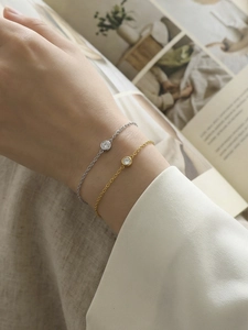 Detailansicht minimalistischer Kettenarmbänder mit gefassten Steinen in Gold und Silber