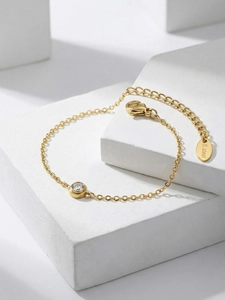 Detail eines 18k vergoldeten Edelstahl-Kettenarmbands mit einem runden Zirkonia-Stein