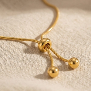Elegant gold adjustable snake chain bracelet with slider bead and round metal pendants