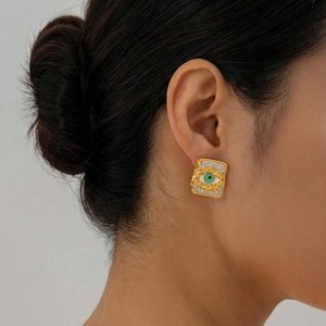 Square Evil Eye stud earring in gold-plated stainless steel worn on ear