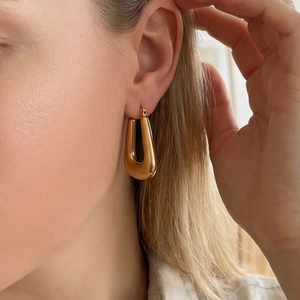 Polished 18k gold plated stainless steel U-shaped chunky hoop earrings on model