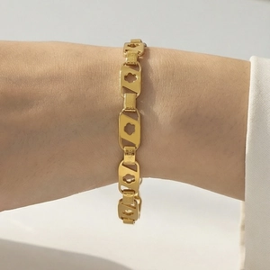 Bracelet doré en acier inoxydable avec motifs floraux ajourés sur maillons rectangulaires