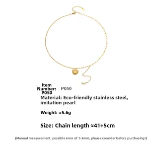 Détail du collier cœur doré avec pendentif perle et chaîne asymétrique en acier inoxydable