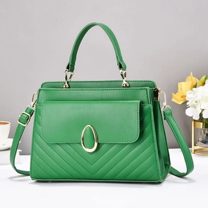 Detail of green V-quilted handbag showing gold hardware and adjustable crossbody strap