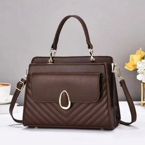 Macro shot of dark brown quilted leather bag with elegant gold oval twist lock detail