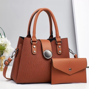 Detail of brown tote bag set featuring vertical wave textures and metallic disk closure