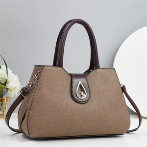 Detail of macaron tote bag showing textured brown fabric with silver teardrop metal lock