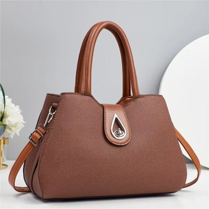 Detail of a brown woven texture handbag featuring a silver teardrop twist lock closure
