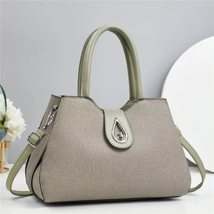 Elegant sage green trapezoid handbag with textured woven finish and metal twist lock