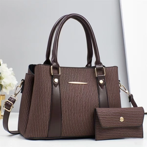 Detail of dark brown pleated shoulder bag set with golden hardware and matching wallet