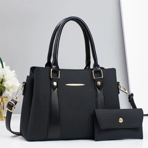 Detail view of the black textured leather handbag set with gold hardware and wallet