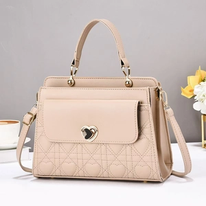 Beige quilted handbag with heart lock and crossbody strap in elegant setting