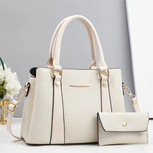 Detail of cream white tote set featuring pleated texture and golden metal hardware