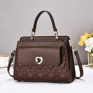 Detail of coffee brown quilted handbag featuring a heart-shaped gold twist lock and texture