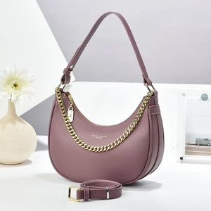 Detail of purple crescent shoulder bag with pebbled leather and gold chain strap