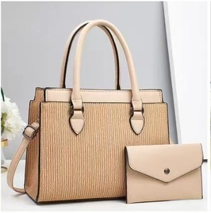 Dettaglio della borsa tote tessuta a righe e pochette abbinata con bordo in pelle