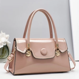 Pink patent leather crossbody bag with golden shell hardware and adjustable strap