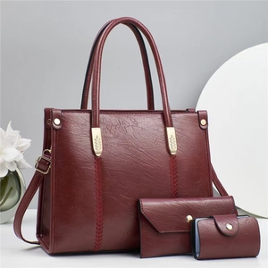 Detailed view of 3-piece burgundy tote set with leaf embroidery and gold hardware