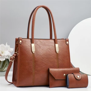 Detailed view of dark brown faux leather 3-piece bag set with golden leaf hardware detail