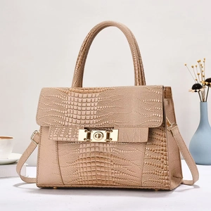 Elegant beige crocodile pattern handbag with gold clasp shown in a lifestyle setting