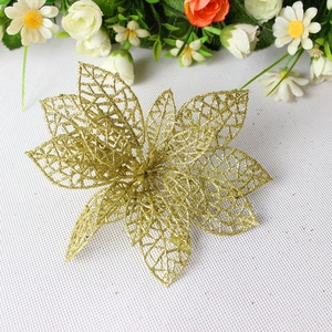 Close-up of golden hollow Christmas flower with glitter coating on white texture