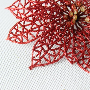 Close-up of red glitter Christmas poinsettia with hollow mesh texture and yellow stamens