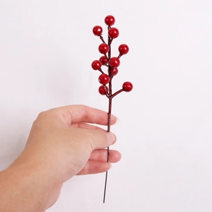 Detailed close-up of artificial red foam berries branch for DIY Christmas tree decoration
