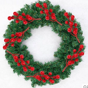 Detail of a Christmas wreath featuring green pine needles and red foam berries