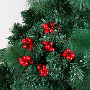 Close-up of artificial pine needles and red foam berries for Christmas tree decoration