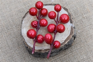 Artificial red berries on a wooden disc with burlap background for Christmas DIY decor