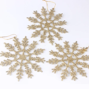 Close-up of golden glitter snowflake ornaments with strings for Christmas tree decoration
