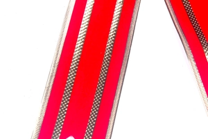 Macro shot of red velvet ribbon with golden metallic textured edges for DIY Christmas decor