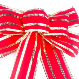 Large Christmas bow featuring red velvet material with elegant gold striped edges